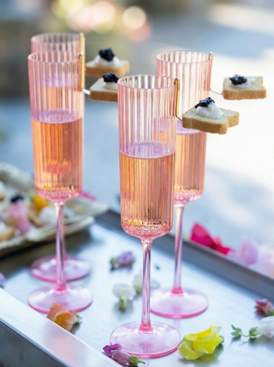 Rosé champagne in fluted glasses with caviar toasts on the rim