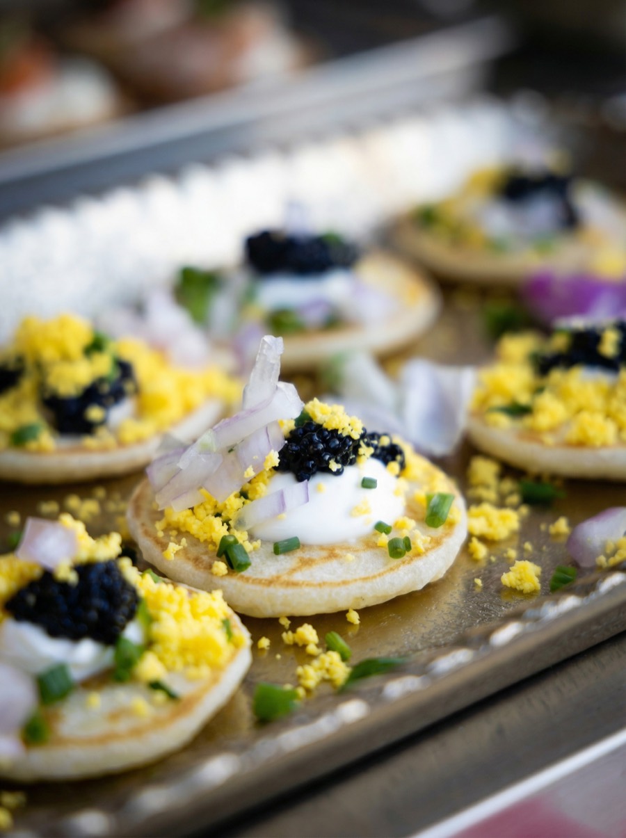 Mini blini with crème fraîche, sieved egg and shallot